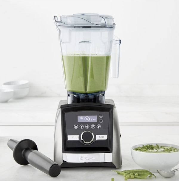 vita mix blender with green smoothie in it.