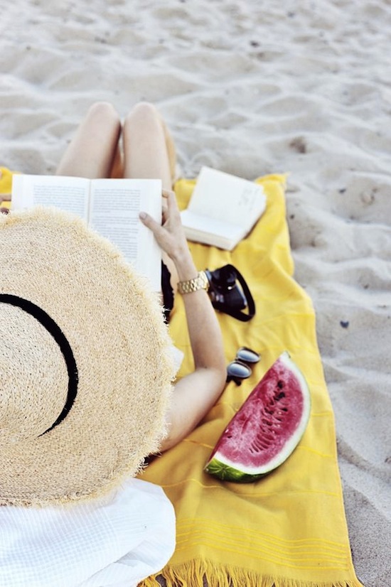 girl on a beach reading a book