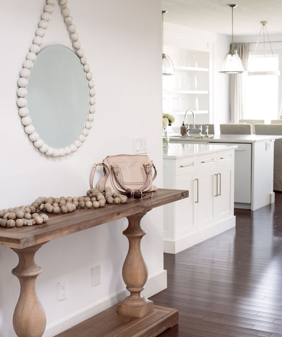 front entry with different shades of cream and white and round mirror