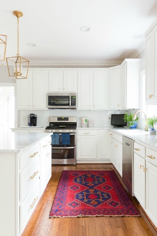 white kitchen with red rug