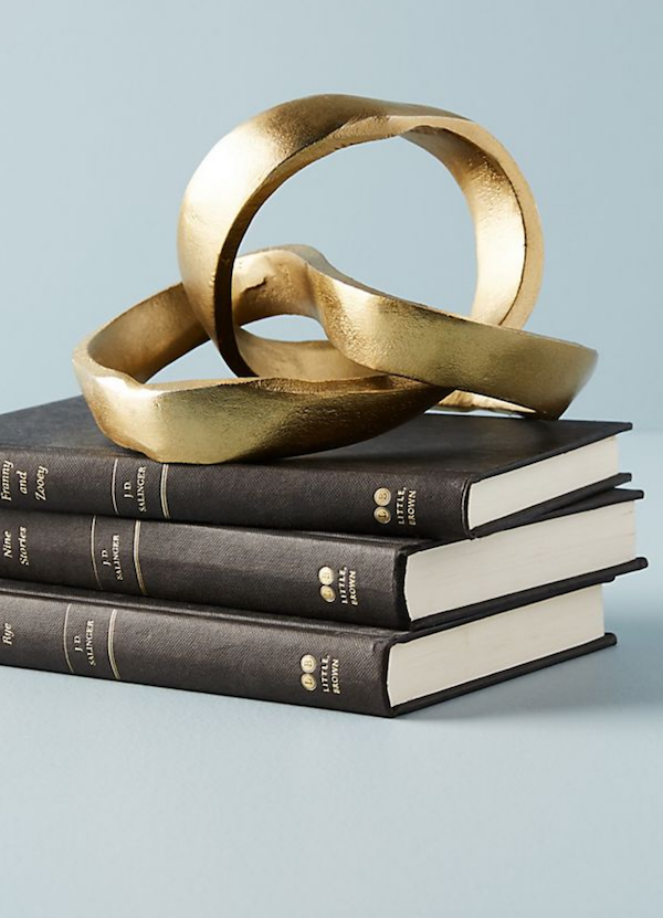 brass knot object on stack of books