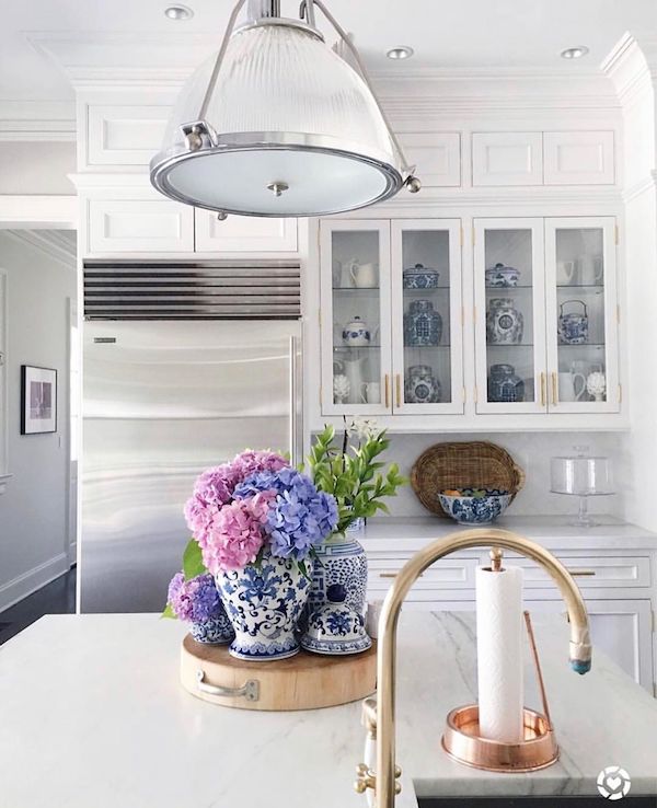 tidy and organized kitchen counters in an all white kitchen with flowers