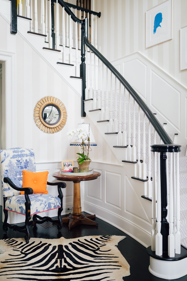 large staircase with white wainscoting along the wall