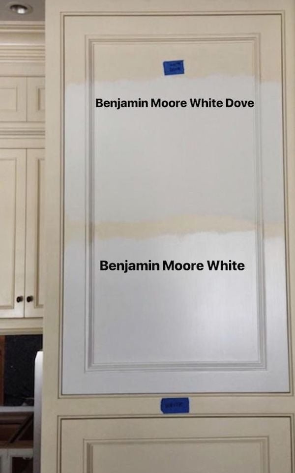 examples of white wall paint samples on a kitchen cabinet