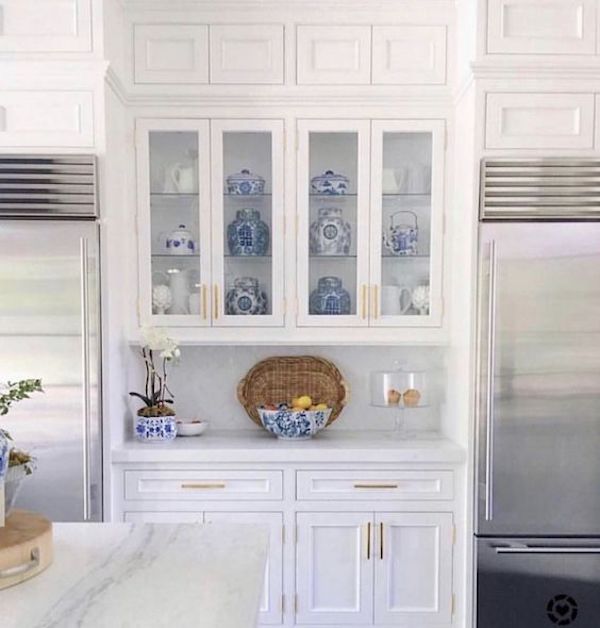 white kitchen with pair of stainless steel refrigerators and glass cabinets