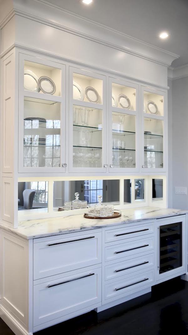 white modern kitchen cabinets with mirrored backsplash