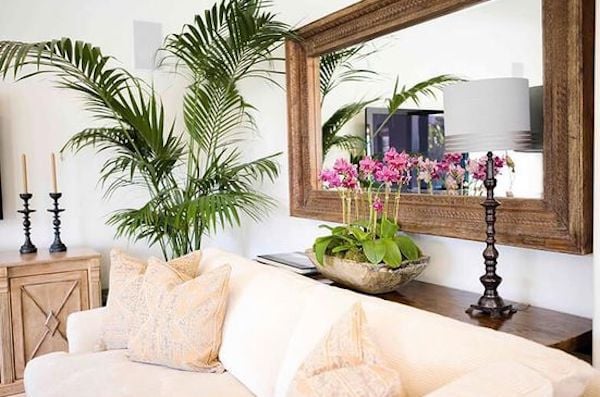 large mirror hung on the large blank wall behind the sofa