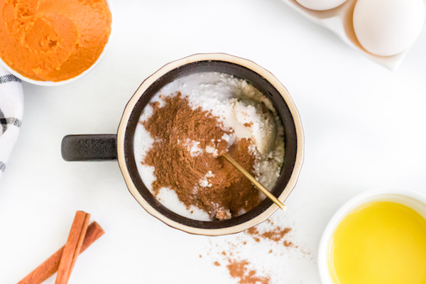 over view of spices and ingredients mixed in mug for pumpkin mug cake