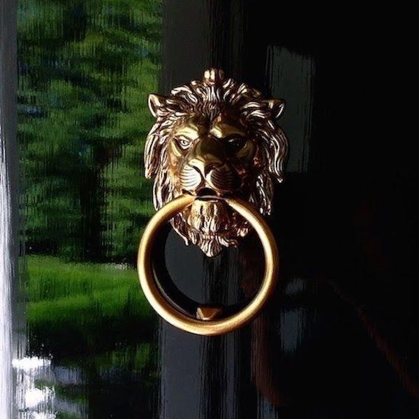 gold door knocker on black door.