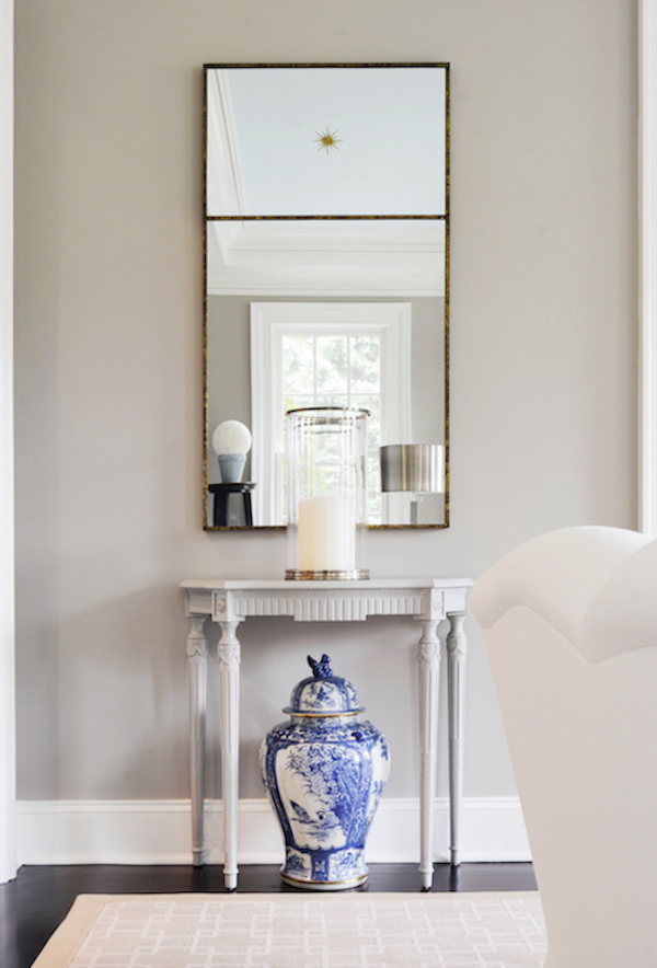 large rectangle mirror over demi lune table.