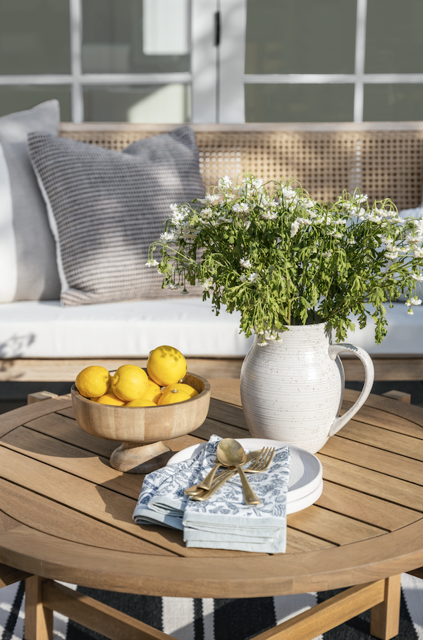 lemons and a white pitcher on a table outside