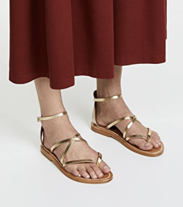gold strappy flat sandals for women on a model.