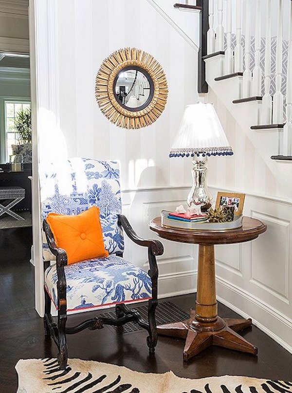 round table with lamp and chair with vintage blue and white fabric.