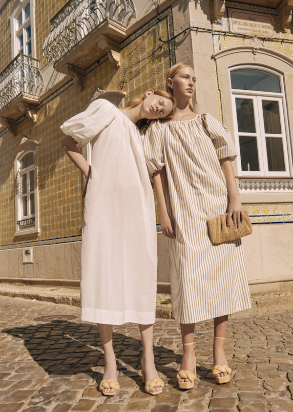 Two women on the street in spring shoes and dresses.