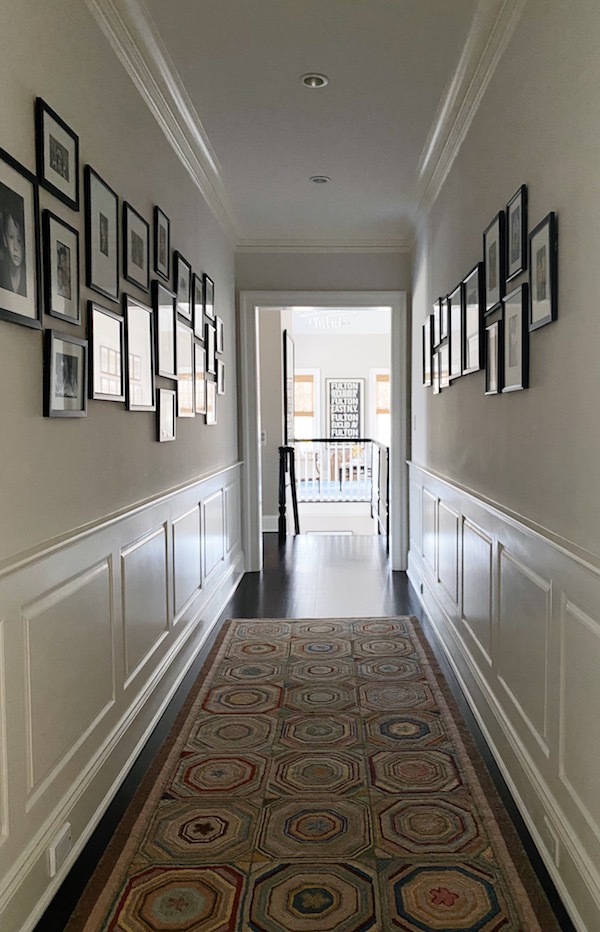 long hallway with gallery wall of photos on both walls.