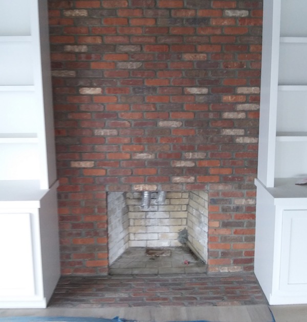 red brick fireplace surround during construction.