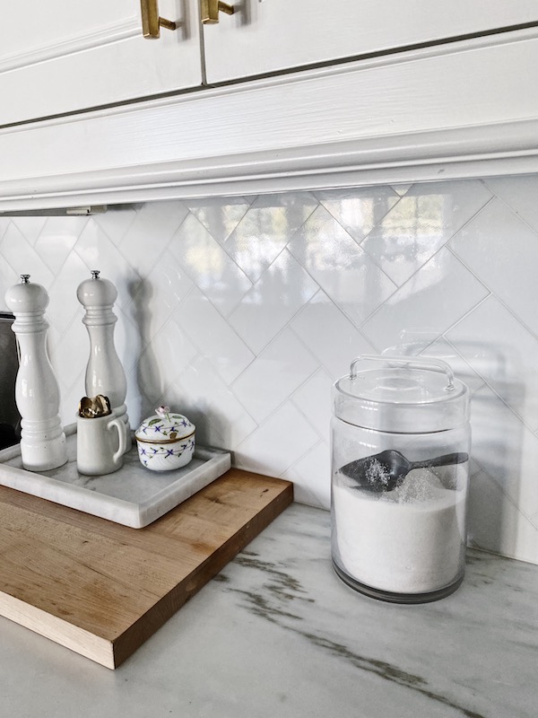 Close up of white kitchen tile backsplash.