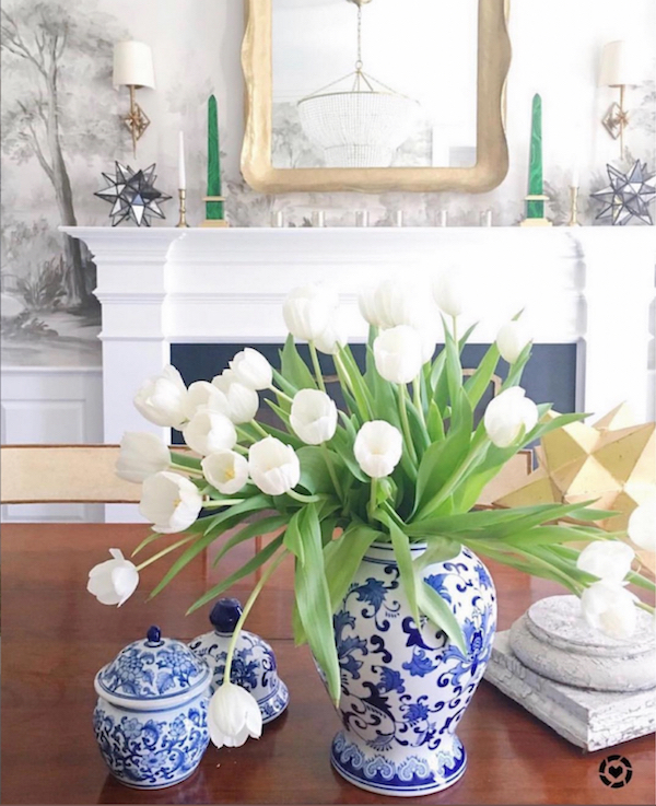 blue and white ginger jars with white tulips on dining room table.