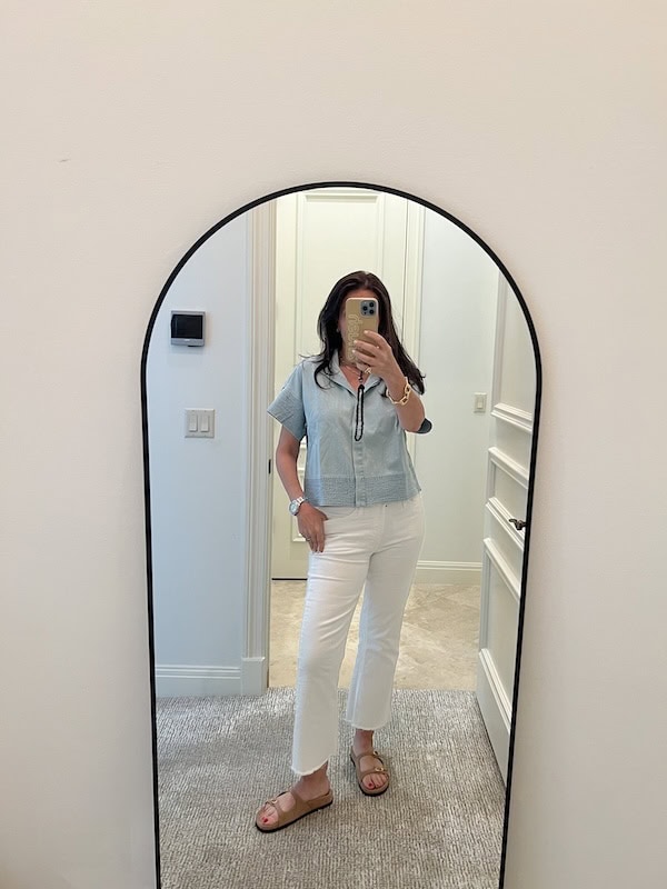 woman in white jeans and blue top.