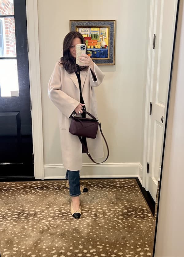 woman in beige coat holding burgundy chic leather bag for fall.
