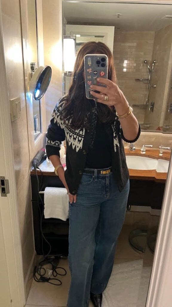 woman in bathroom mirror wearing winter outfit.