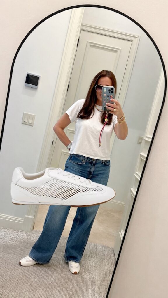 over 50 woman wearing jeans, t shirt and white mesh sneakers.