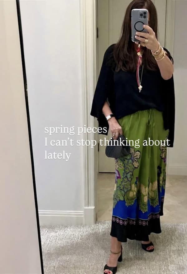 woman in black top and green spring skirt outfit.