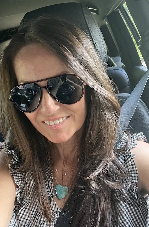 woman in sunglasses sitting in car.